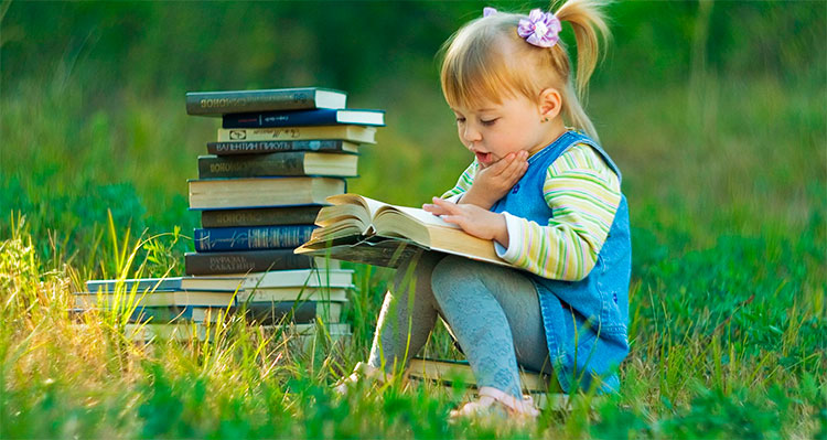 девочка с книгами в траве