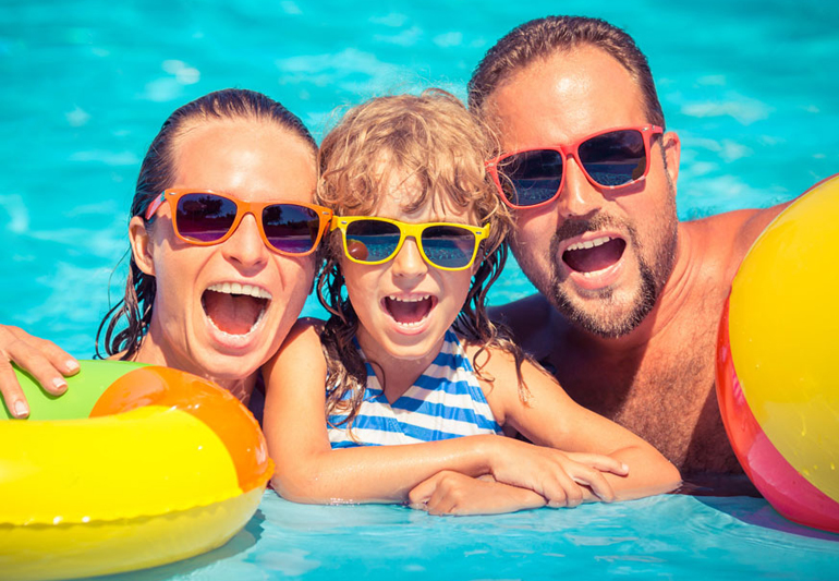 семья в бассейне в солнцезащитных очках