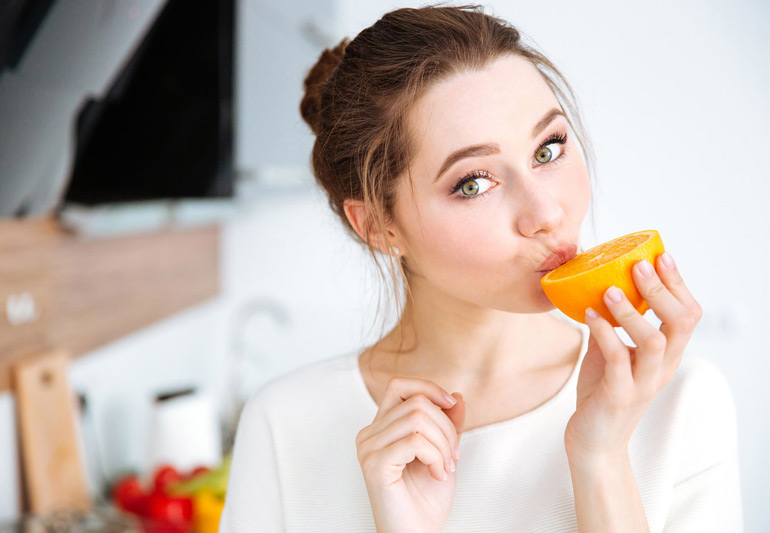 девушка ест апельсин