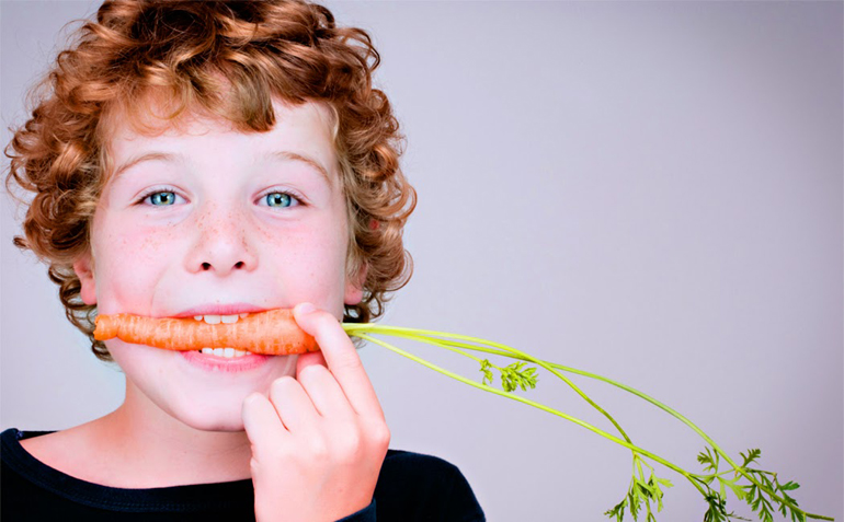 мальчик кусает морковь